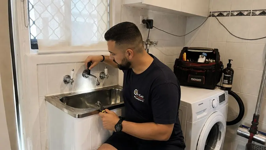 Plumber inspecting laundry tap plumbing, Mentone