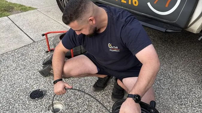 Plumber preparing a drain cleaning hose, Mentone