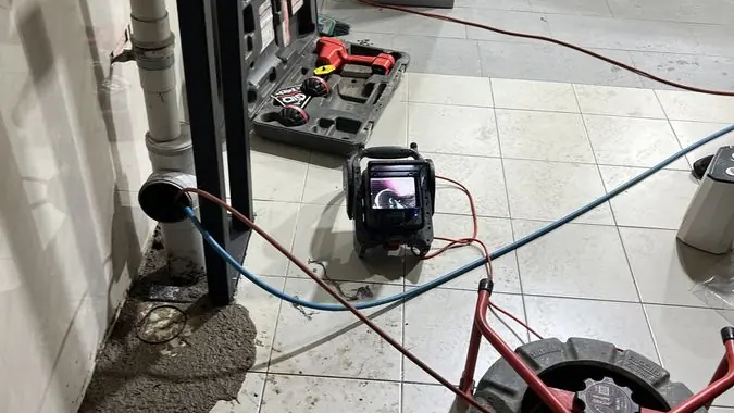 Drain cleaning equipment inside a bathroom, Mentone